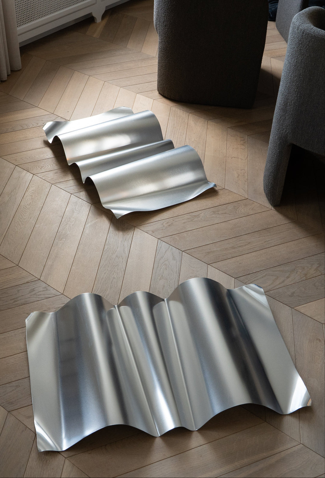 Metallic wavy floor art on a wooden floor